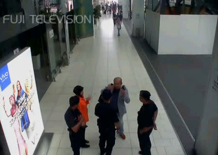 A still image from a CCTV footage appears to show a man purported to be Kim Jong Nam talking to security personnel, after being accosted by a woman in a white shirt, at Kuala Lumpur International Airport in Malaysia on February 13, 2017. FUJITV/via Reuters TV