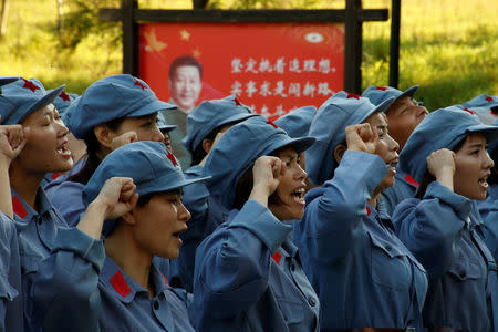 Participants dressed in replica red army uniforms swear an oath during a Communist team-building course extolling the spirit of the Long March in the mountains outside Jinggangshan, Jiangxi province, China, September 14, 2017. REUTERS/Thomas Peter