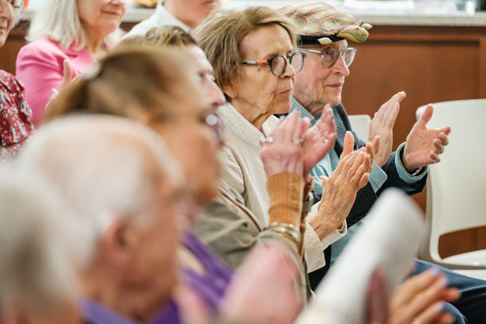 People applaud former Ohio Gov. Richard Celeste as he approaches the lectern for a talk Saturday at the Dover Public Library.