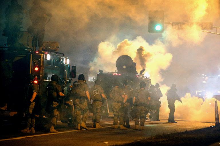 Police attempt to control demonstrators in Ferguson, Missouri on August 18, 2014 protesting the killing of unarmed teenager Michael Brown