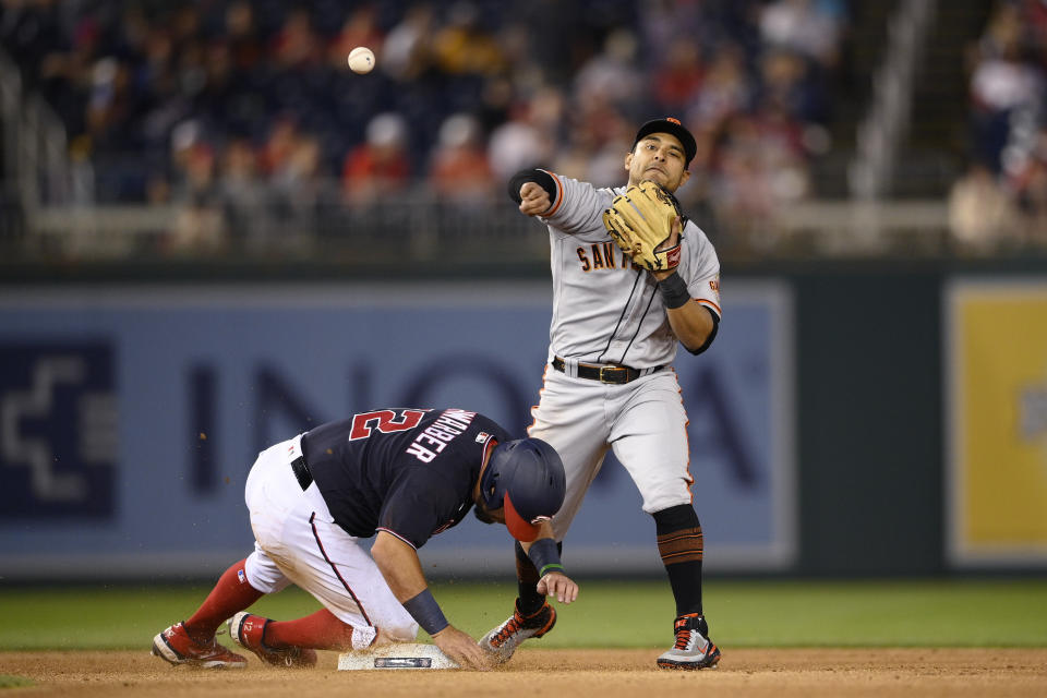 Washington Nationals' Kyle Schwarber (12) is out at second as San Francisco Giants second baseman Donovan Solano, right, throws to first to complete the double play on Yan Gomes during the fifth inning of a baseball game Friday, June 11, 2021, in Washington. (AP Photo/Nick Wass)