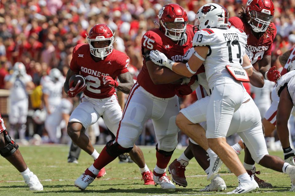 Oklahoma's Jovantae Barnes (2) carries the ball as Walter Rouse (75) blocks Arkansas State's Gavin Potter (13) during a college football game between the University of Oklahoma Sooners (OU) and the Arkansas State Red Wolves at Gaylord Family-Oklahoma Memorial Stadium in Norman, Okla., Saturday, Sept. 2, 2023. Oklahoma won 73-0.