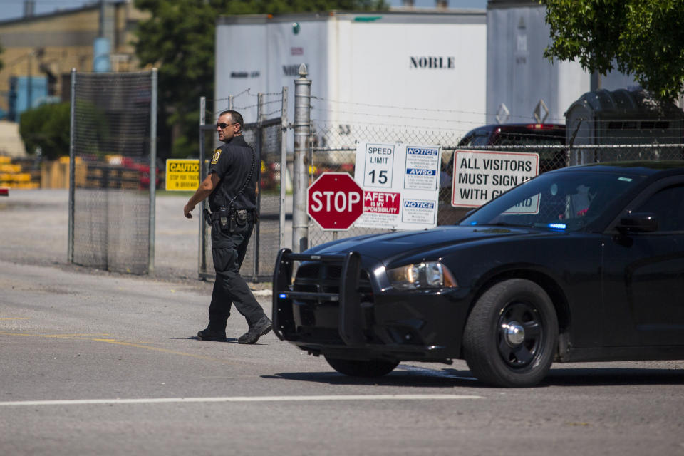 A police officer walks at the entrance to a Mueller Co. fire hydrant plant where police said multiple people were shot to death and others were wounded in Albertville, Ala., on Tuesday, June 15, 2021. (AP Photo/Vasha Hunt)