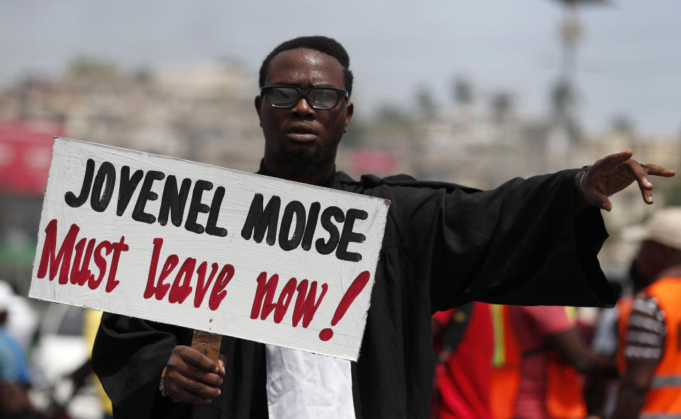 A demonstrator dressed in lawyer's robes joins a protest calling for the resignation of President Jovenel Moise, in Port-au-Prince, Haiti, Friday, Oct. 4, 2019. After a two-day respite from the recent protests that have wracked Haiti's capital, opposition leaders urged citizens angry over corruption, gas shortages, and inflation to join them for a massive protest march to the local headquarters of the United Nations.(AP Photo/Rebecca Blackwell)