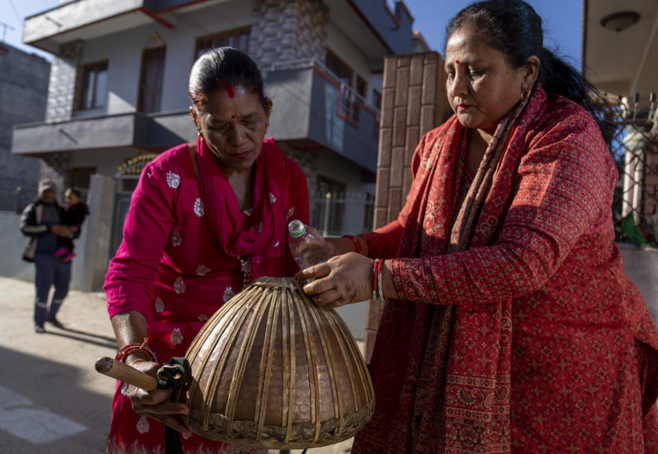 Machindra Thapa, 47, right, and Vishnu Maya Chettri, 52, prepare the Damaha, one of the instruments of the naumati baja, before a rehearsal in Kathmandu, Nepal, Tuesday, March 5, 2024. Once associated only with men from the Damai community, part of the lowest caste, nine women from varied castes have come together in this band to play the naumati baja, or nine traditional instruments. (AP Photo/Niranjan Shrestha)