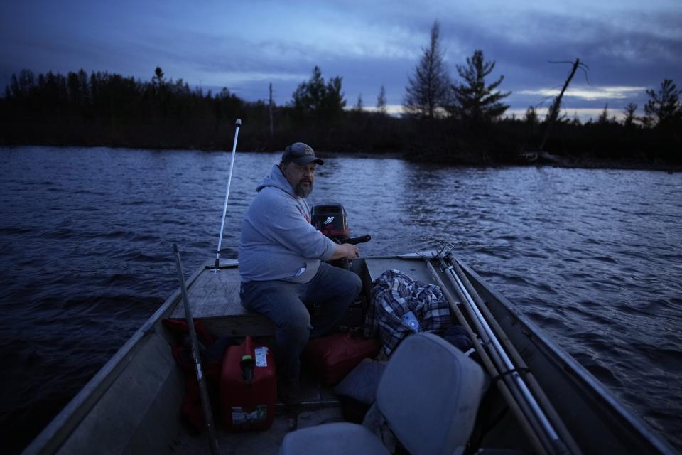 Jason Bisonette drives his boat while spearfishing with his son on the Chippewa Flowage Monday, April 15, 2024, near Hayward, Wis. (AP Photo/John Locher)