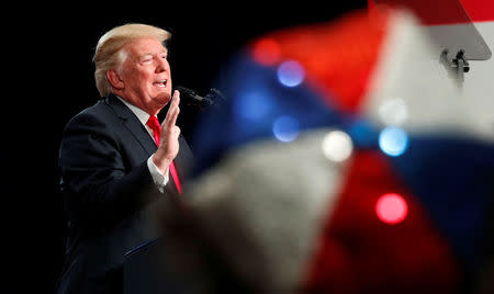 A woman wearing a red white and blue hat listens as U.S. President Donald Trump speaks about tax reform legislation during a visit to St. Louis, Missouri, U.S. November 29, 2017. REUTERS/Kevin Lamarque