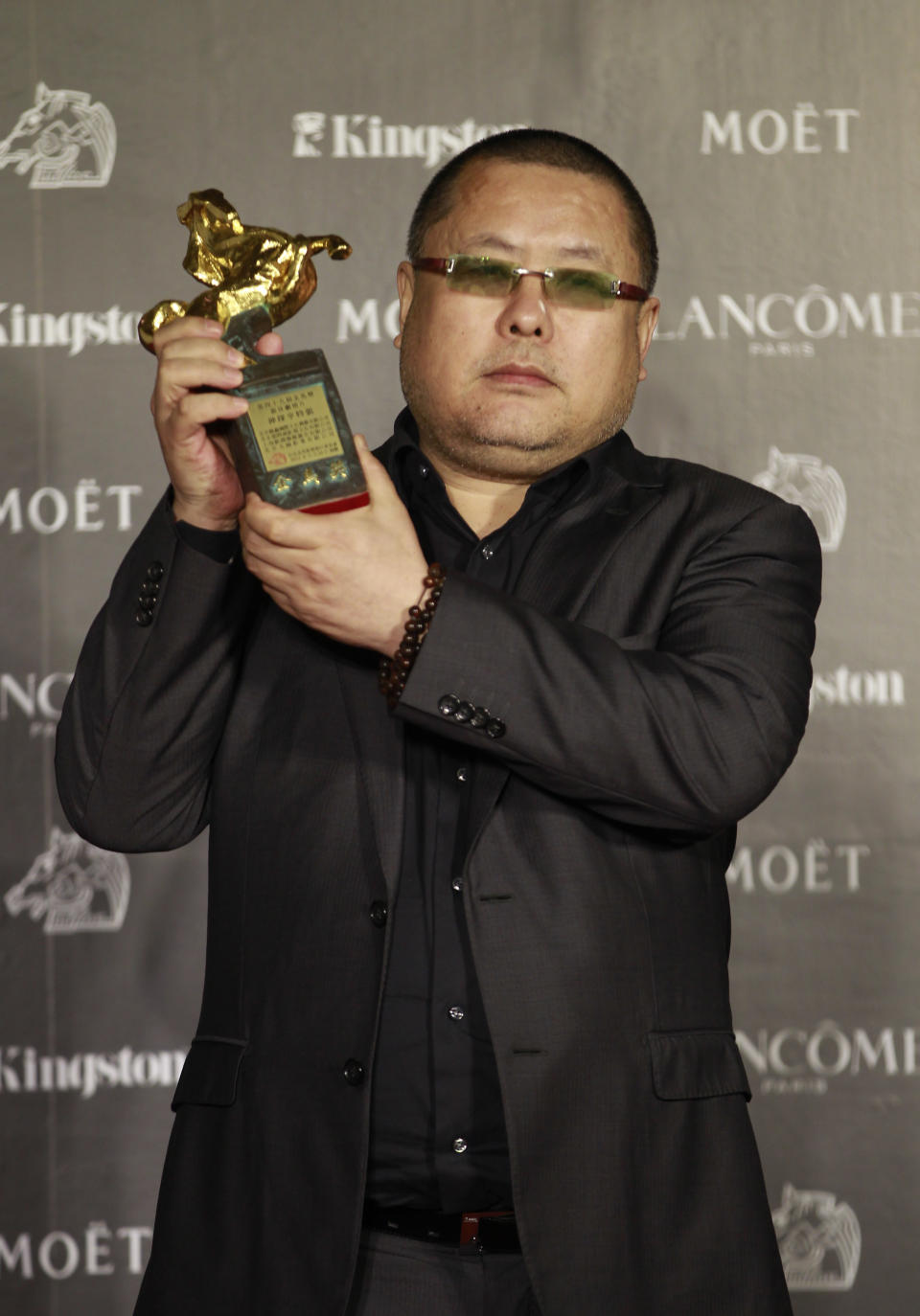 Chinese director Gao QunShu holds his award for the Best Feature Film for the film "Beijing Blues" at the 49th Golden Horse Awards at the Luodong Cultural Working House in Yilan County, Taiwan, Saturday, Nov. 24, 2012. The Golden Horse awards are one of the Chinese-language film industry's biggest annual events. (AP Photo/Chiang Ying-ying)