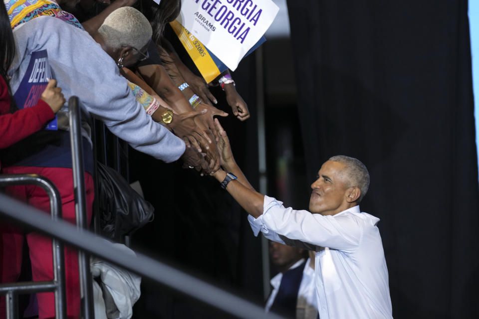 Former President Barack Obama greets supporters as he walks to the stage to speak at campaign rally for Georgia gubernatorial candidate Stacey Abrams and U.S. Sen. Raphael Warnock, D-Ga., candidate for U.S. Senate, Friday, Oct. 28, 2022, in College Park, Ga. (AP Photo/John Bazemore)