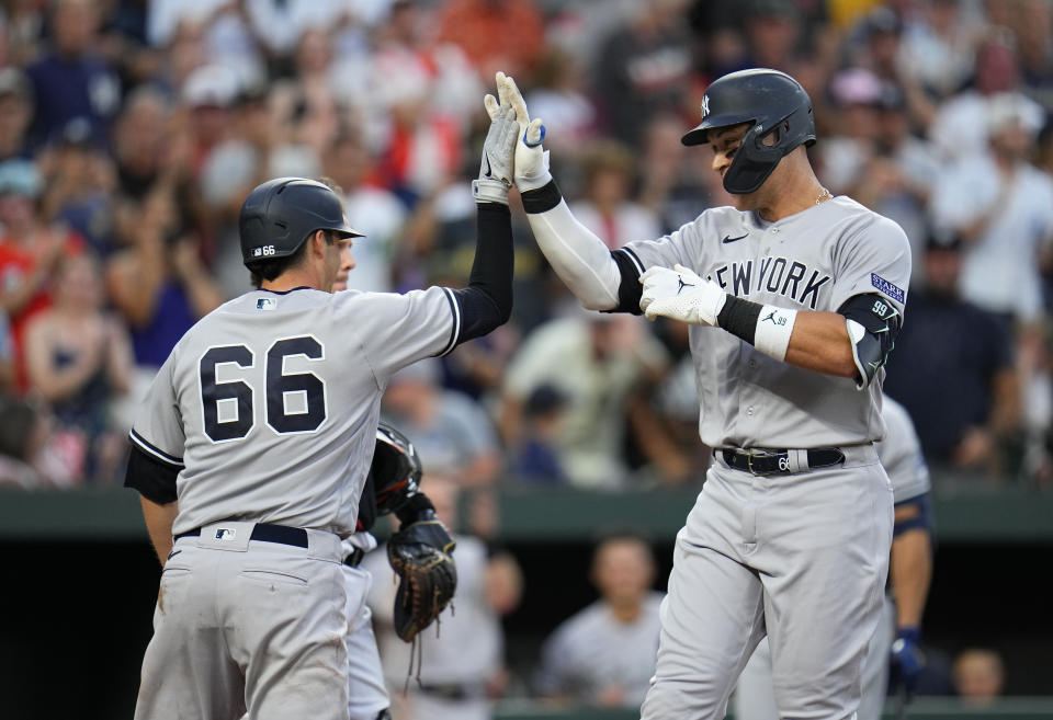 New York Yankees' Aaron Judge, right, is greeted near home plate by Kyle Higashioka (66) after scoring them on a two-run home run off Baltimore Orioles starting pitcher Tyler Wells during the third inning of a baseball game, Saturday, July 29, 2023, in Baltimore. (AP Photo/Julio Cortez)