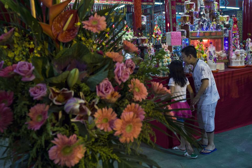 Children look at food and incense offered during the Chinese Hungry Ghost Festival in Hong Kong