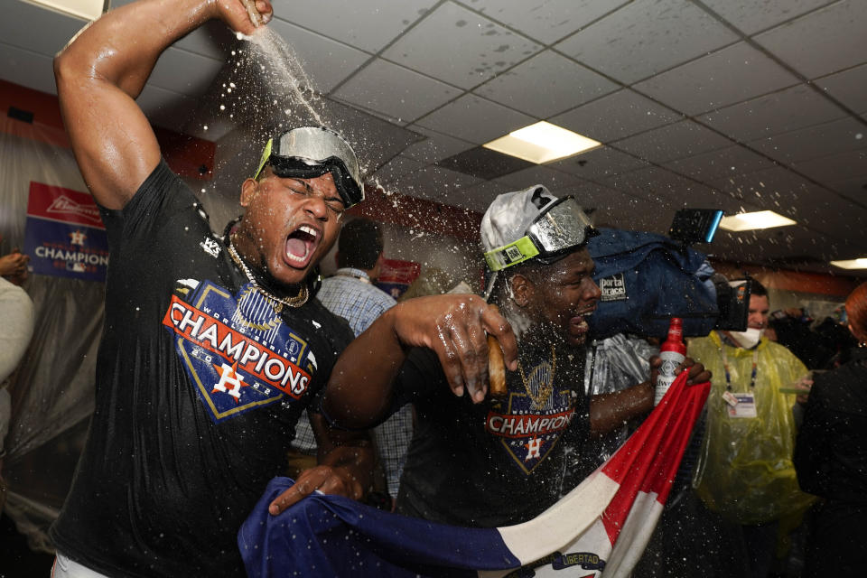 Los dominicanos Framber Valdez y Héctor Neris festejan la coronación en la Serie Mundial, tras derrotar a los Filis de Filadelfia en el sexto juego, el domingo 6 de noviembre de 2022 (AP Foto/David J. Phillip)