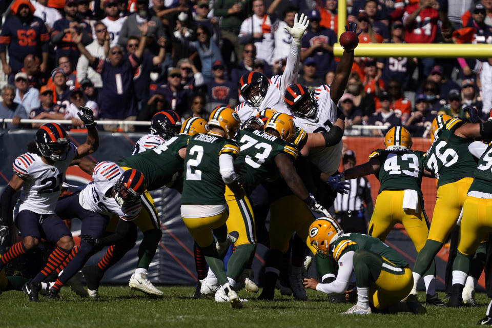 Green Bay Packers kicker Mason Crosby, left, kicks a field goal off the hold of Corey Bojorquez during the first half of an NFL football game against the Chicago Bears Sunday, Oct. 17, 2021, in Chicago. (AP Photo/David Banks)