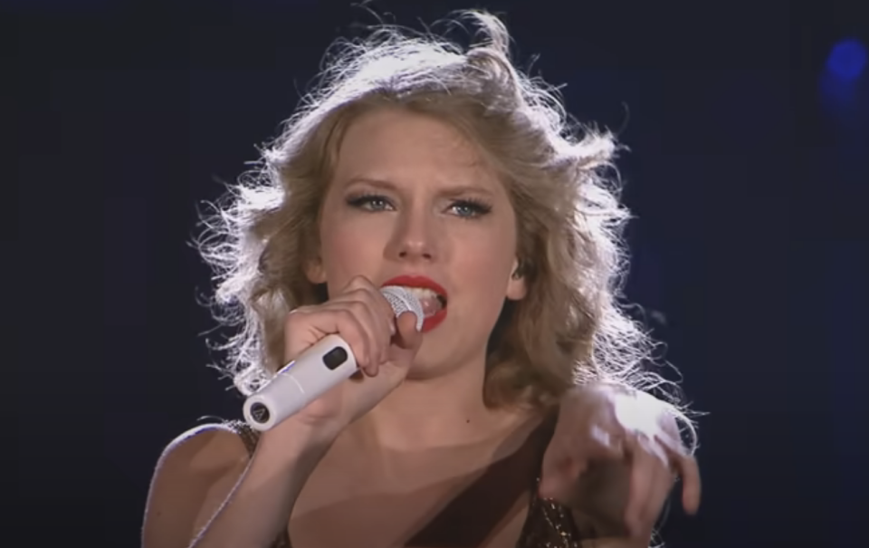 Taylor Swift performing on stage with a microphone