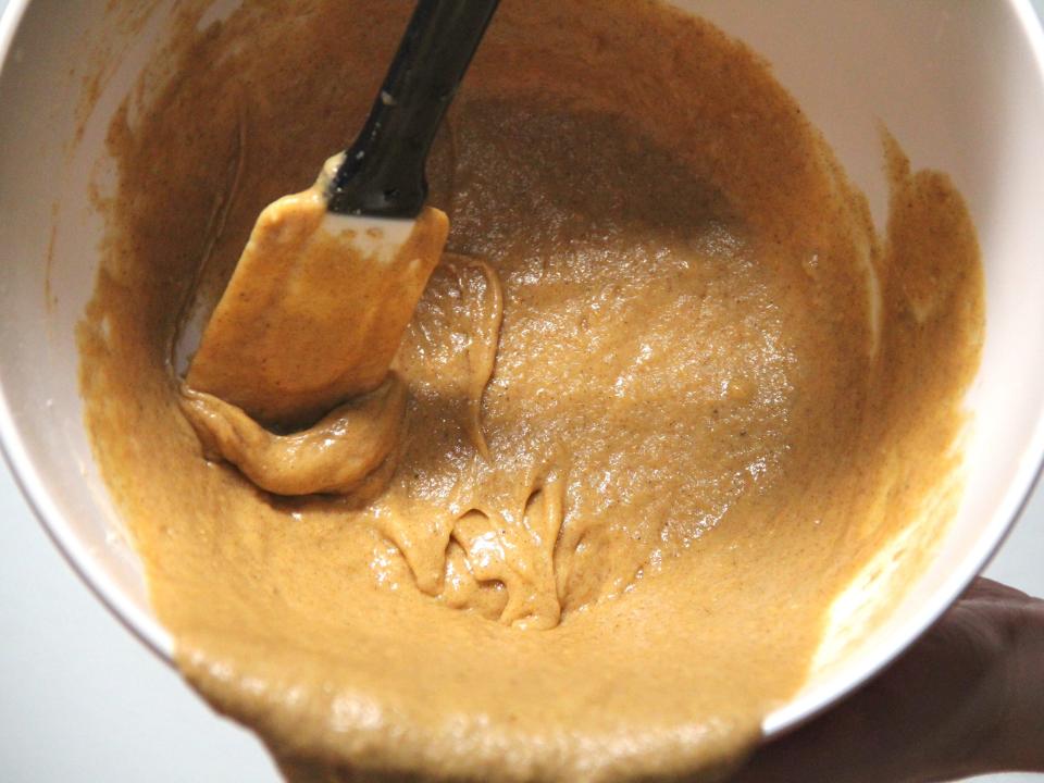 Scraping Pillsbury pumpkin bread batter out of a bowl.