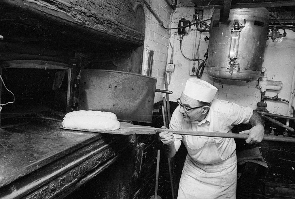 2nd December 1974: Baker Roy Edwards slides a loaf into his oven. 