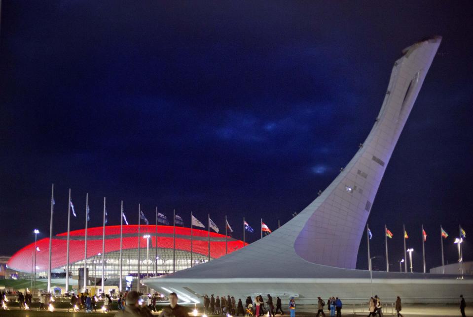 FILE - In this Feb. 1, 2014, file photo, the roof of the Bolshoy Ice Dome is lit in red as the Olympic cauldron stands at right in the Olympic Park before the start of the 2014 Winter Olympics in Sochi, Russia. Thirty-four years after the Moscow summer Olympics of 1980, President Vladimir Putin intends to prove to the world through the 2014 Sochi games that post-Soviet Russia remains a global player. (AP Photo/David Goldman, File)