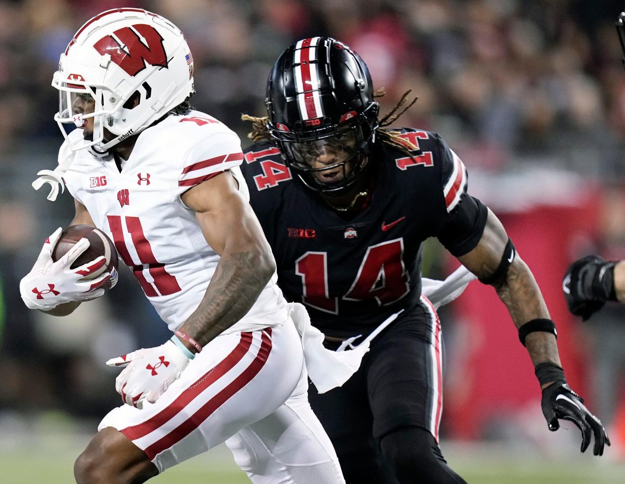 Sep 24, 2022; Columbus, Ohio, USA; Ohio State Buckeyes safety Ronnie Hickman (14) tackles Wisconsin Badgers wide receiver Skyler Bell (11) in the third quarter of the NCAA football game between Ohio State Buckeyes and Wisconsin Badgers at Ohio Stadium. 