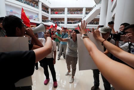 Pro-government and anti-government supporters chant against one another at a shopping mall in Hong Kong