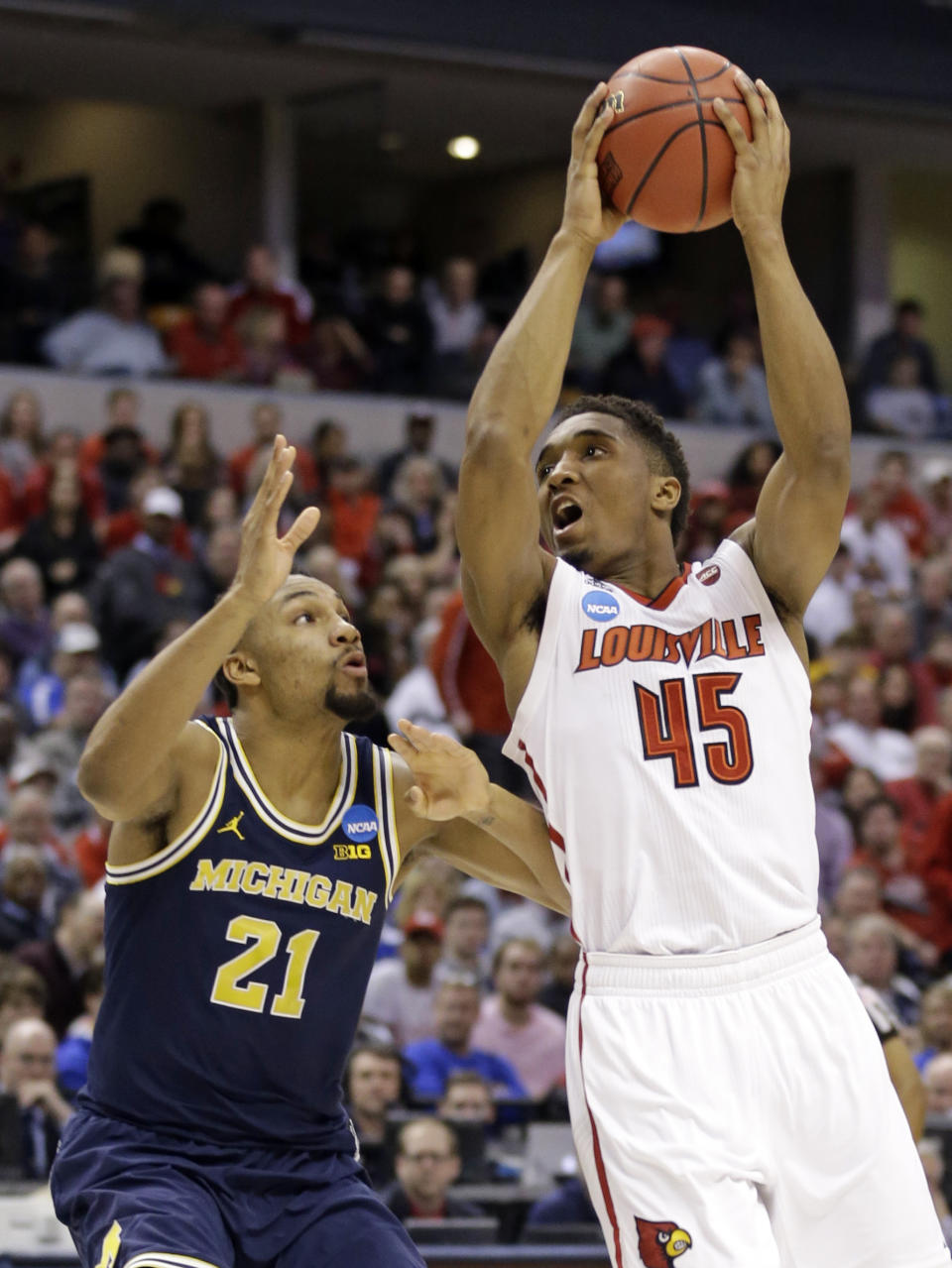 Louisville guard Donovan Mitchell (45) shoots over Michigan guard Zak Irvin (21) during the first half of a second-round game in the men’s NCAA college basketball tournament in Indianapolis, Sunday, March 19, 2017. (AP Photo/Michael Conroy)