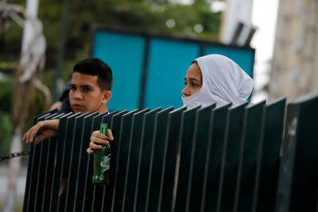 Demonstrators look from behind a barricade as they take part in a rally against Venezuela's President Nicolas Maduro in Caracas, Venezuela April 24, 2017. REUTERS/Carlos Garcia Rawlins