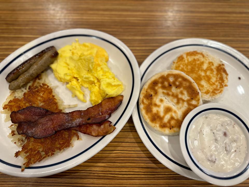 hash brown, sausage, eggs, bacon, and biscuits, and gravy on two plates at IHOP