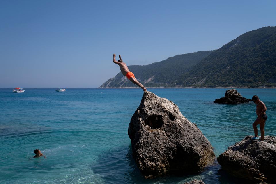 <p>A man dives at Agios Nikitas beach on the island of Lefkada, Greece</p> (Reuters)