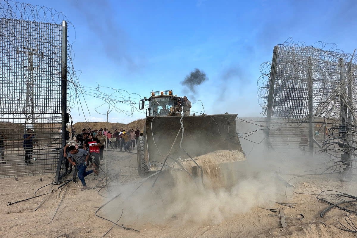 Palestinians break into the Israeli side of Israel-Gaza border fence after gunmen infiltrated areas of southern Israel (Reuters)