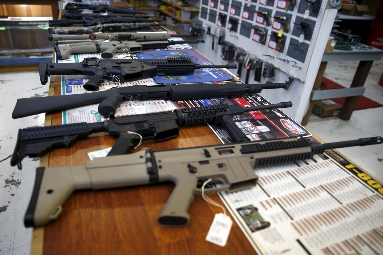Automatic firearms set out on a counter for sale, with cards giving their specifications.