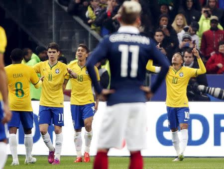 Brazil's Neymar JR (R) celebrates with his team mates after scored against France during their international friendly soccer match at the Stade de France, in Saint-Denis, near Paris, March 26, 2015. REUTERS/Charles Platiau