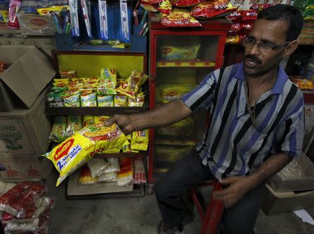 A vendor sells a Maggi noodles packet to a customer (not pictured) inside a grocery shop in Kolkata, India, June 3, 2015. REUTERS/Rupak De Chowdhuri