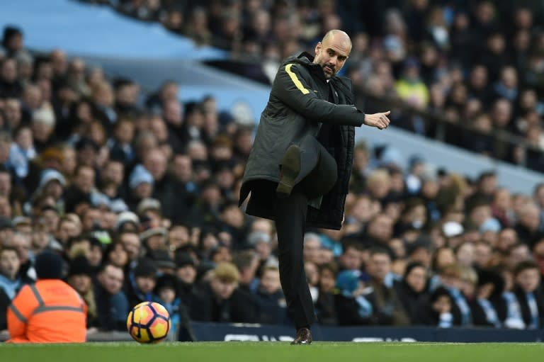 Manchester City's manager Pep Guardiola kicks the ball back onto the pitch during their English Premier League match against Burnley, at the Etihad Stadium in Manchester, on January 2, 2017