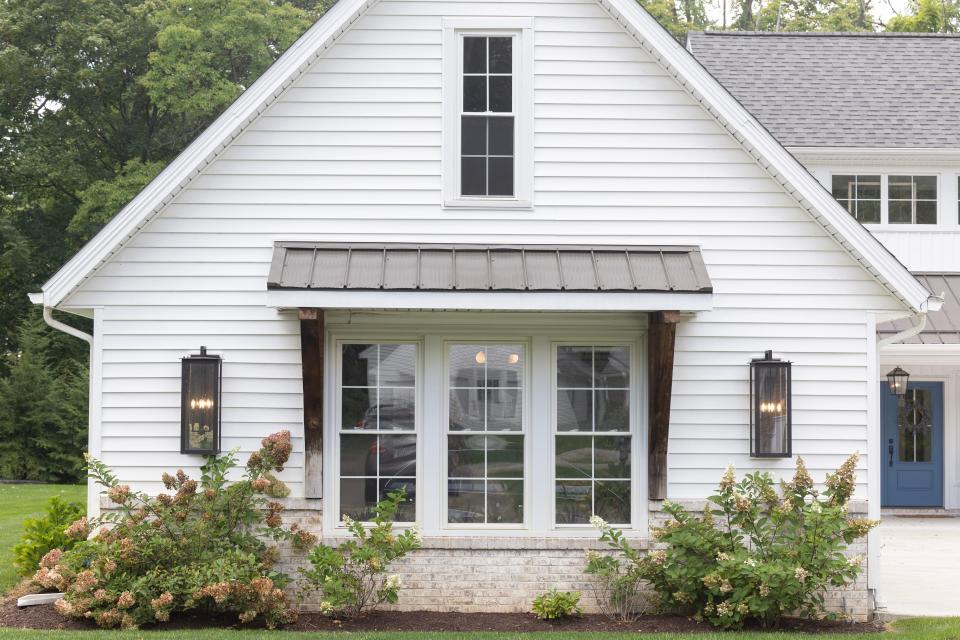 Three large windows admit abundant natural light into the garage of the modern farmhouse shared by Michael Kell and Sally Goodnow in Plain Township. It displays features of the style popularized by HGTV stars Chip and Joanna Gaines: metal roofing accents, rough-sawn wood timbers and a palette dominated by white, gray and black.