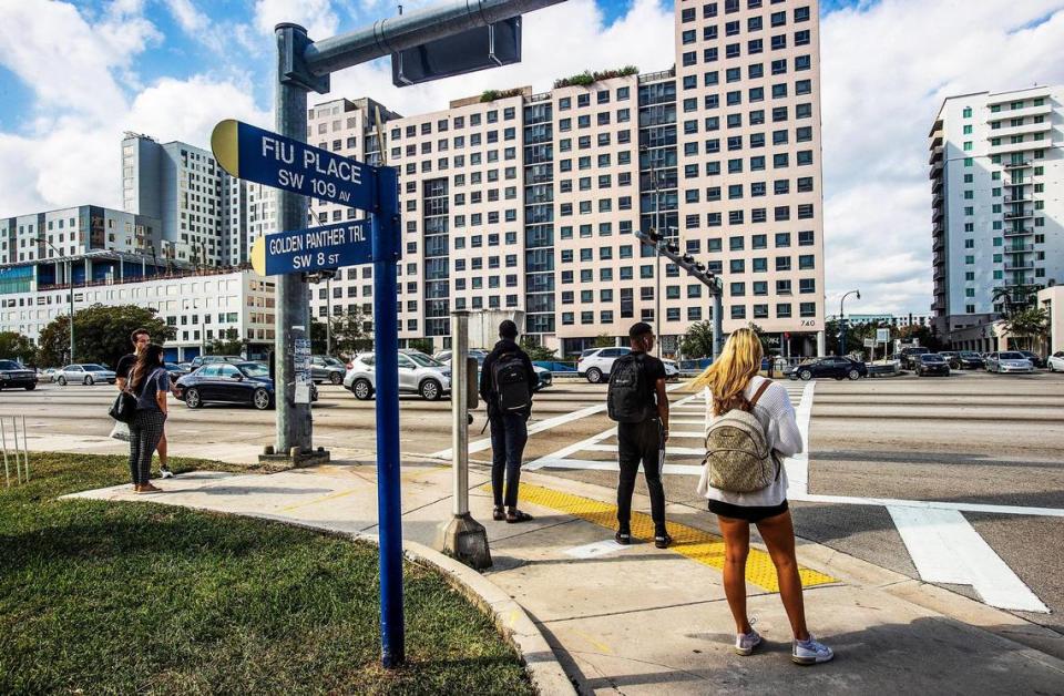 Florida International University students wait to cross Southwest Eighth Street at 109th Avenue, where a pedestrian bridge collapsed while under construction in 2018. Construction will start in early 2024 on a new bridge to link FIU’s main campus with Sweetwater’s University City, seen in the background.