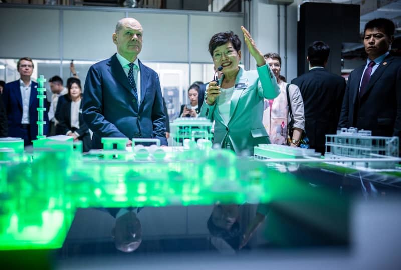 German Chancellor Olaf Scholz (L) visits the Covestro Innovation Center, where new developments in plastics and recycled materials are created. Scholz is scheduled to meet China's President Xi Jinping in Beijing at the end of his trip. Michael Kappeler/dpa