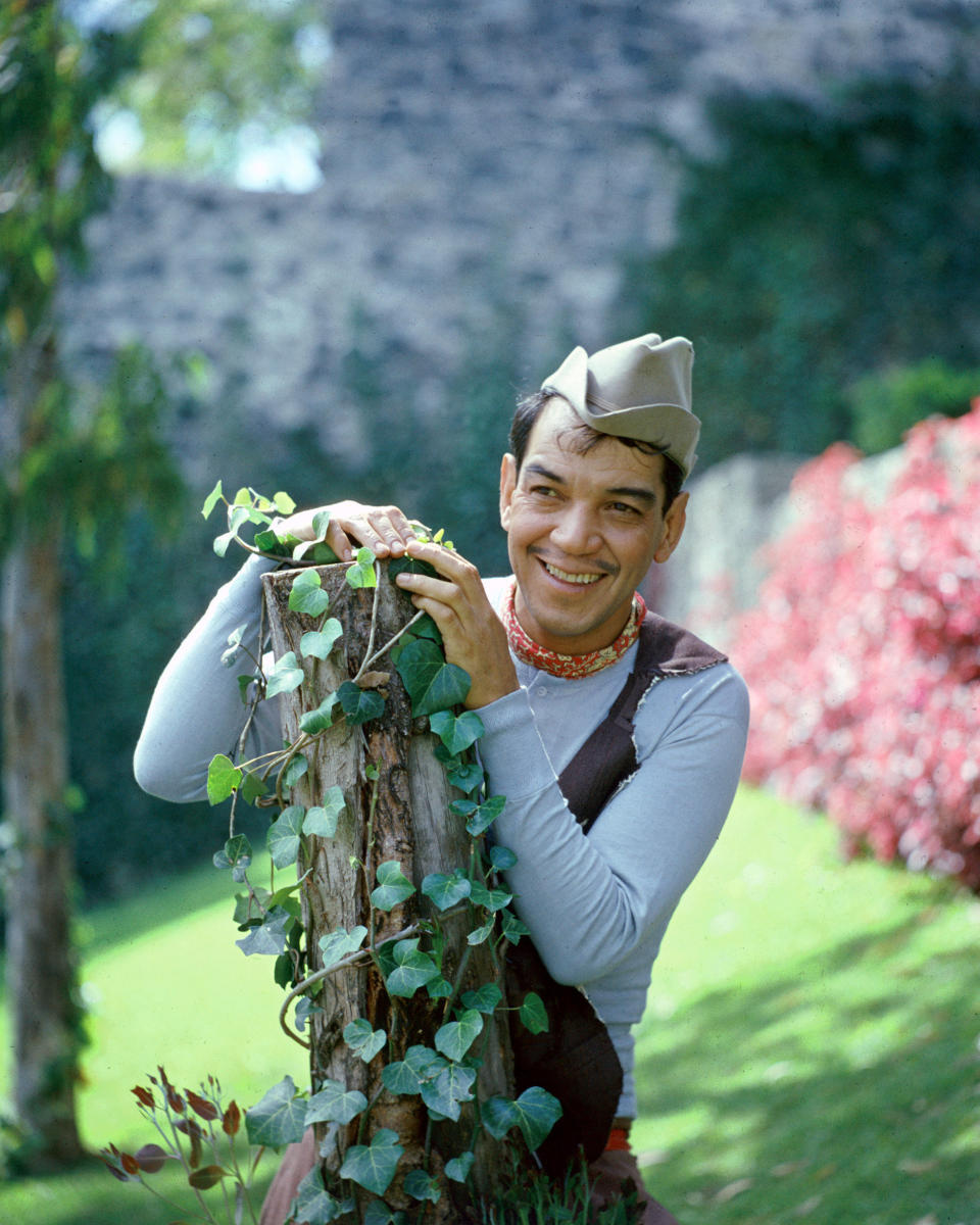 Mexican actor and comedian Cantinflas (1911 - 1993), born Mario Moreno Reyes, looking Puckish behind an ivy-covered stump, circa 1950. (Photo by Silver Screen Collection/Hulton Archive/Getty Images)