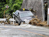 <p>Japan Ground Self-Defense Force members search missing people near a damaged taxi after flooding caused by heavy rains hit Hiroshima, southwestern Japan, Thursday, July 12, 2018. (Photo: Ryosuke Ozawa/Kyodo News via AP) </p>