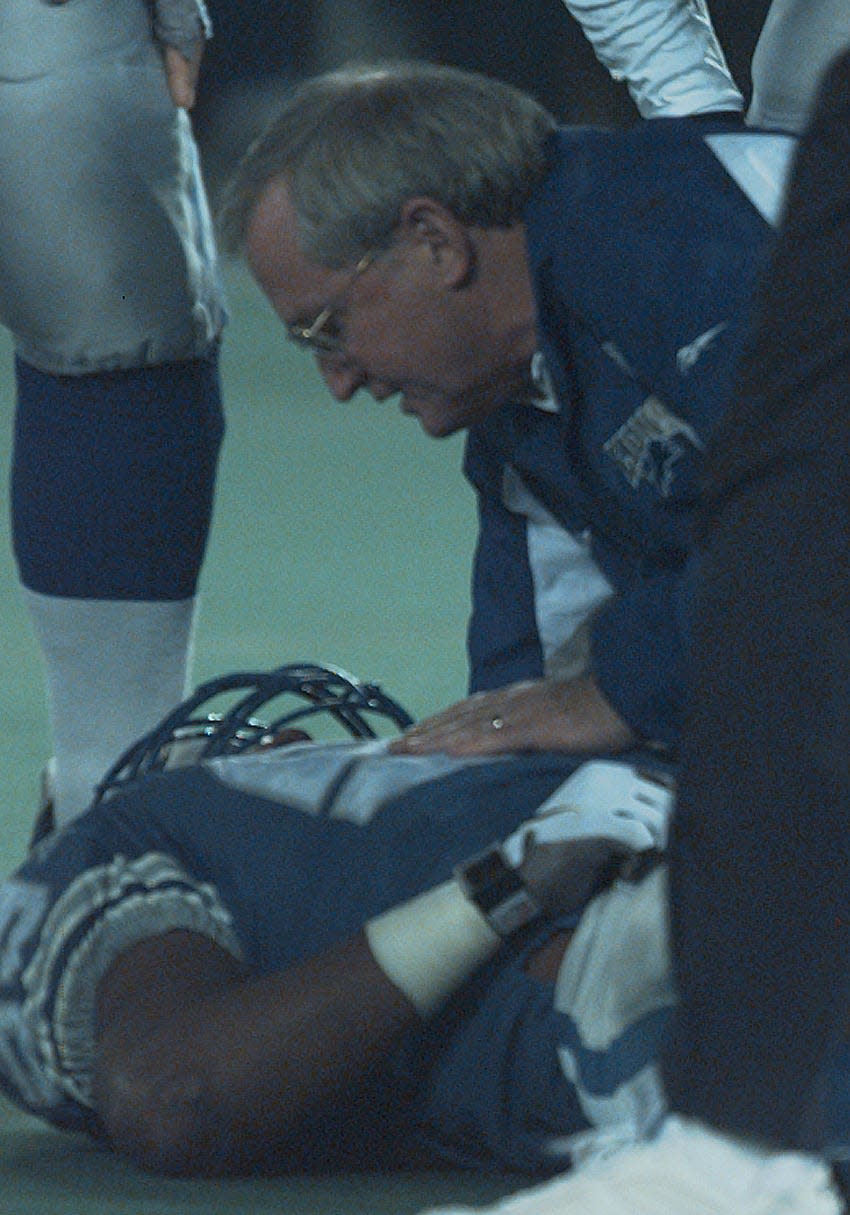 Lions linebacker Reggie Brown lies on the field after spine injury on Dec. 21, 1997, at the Silverdome is attended to by team trainer Kent Falb. He was not breathing and was intubated on the field.