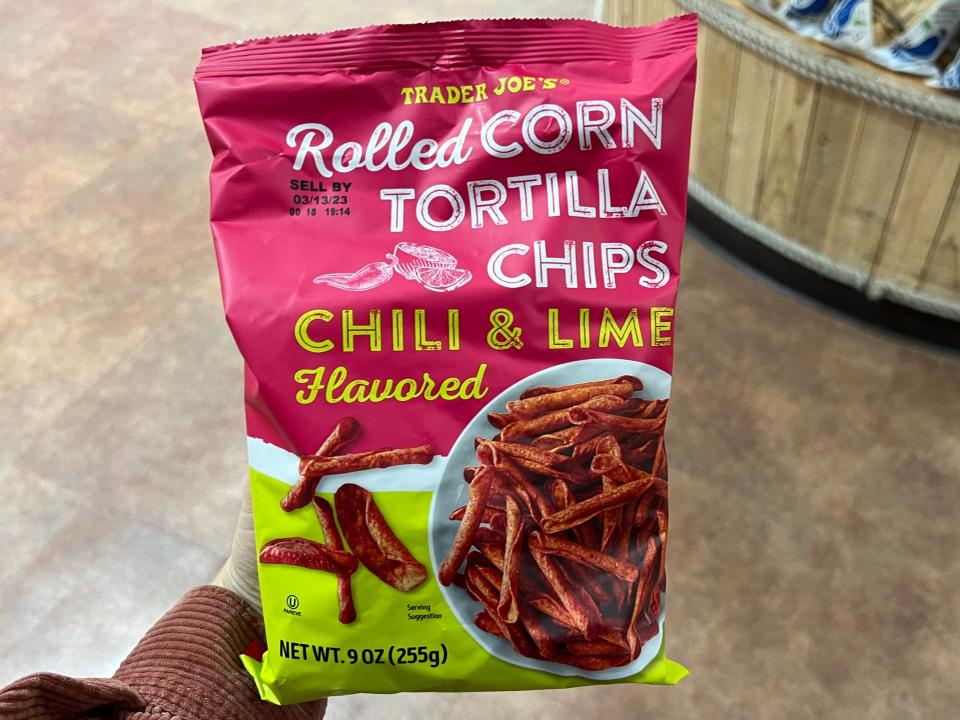 The writer holds a bag of rolled corn tortilla chili-lime chips