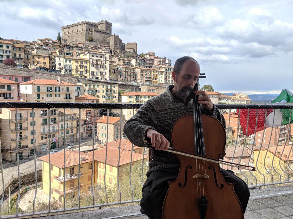 Man playing instrument on balcony in Italy 