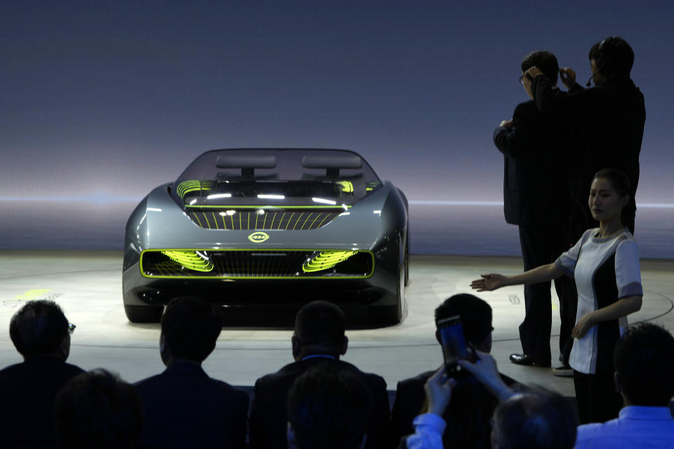 Attendees look at the Nissan Max-Out concept car displayed during the Auto Shanghai 2023 show in Shanghai, Tuesday, April 18, 2023. Global and Chinese automakers plan to unveil more than a dozen new electric SUVs, sedans and muscle cars this week at the Shanghai auto show, their first full-scale sales event in four years in a market that has become a workshop for developing electrics, self-driving cars and other technology. (AP Photo/Ng Han Guan)