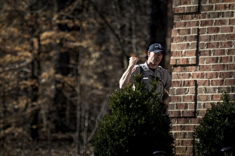 Fairfax County police officer speaks with a local resident while on the hunt for accused bank robber Assaye, who escaped Inova Fairfax Hospital early Tuesday in Fairfax