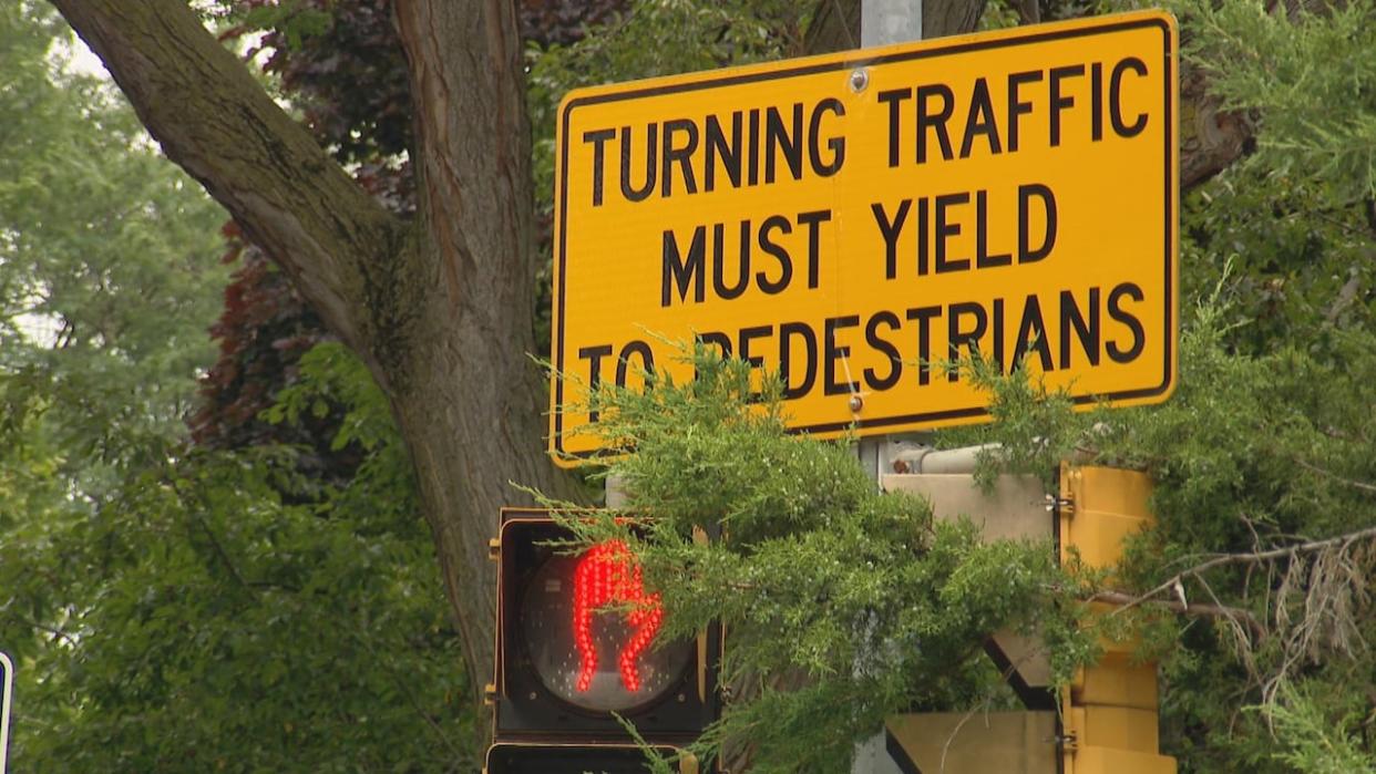 A sign on Parkside Drive tells motorists to yield to pedestrians. Residents of the street say the city needs to make more changes to make the street safer.  (Paul Borkwood/CBC - image credit)