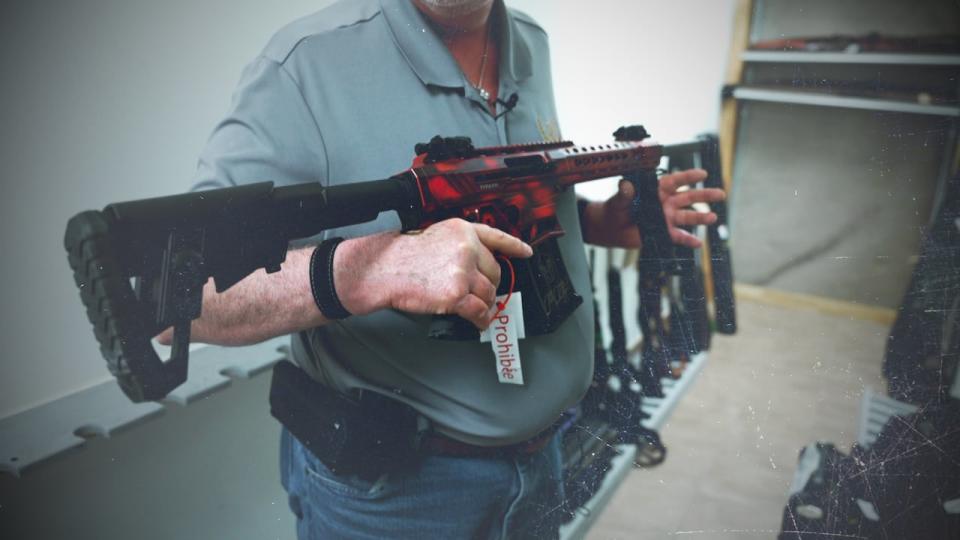 Pierre Pharand, co-owner of a shooting club in L’Ange-Gardien, Que., holds a banned firearm that he keeps under lock and key.  (Radio-Canada - image credit)