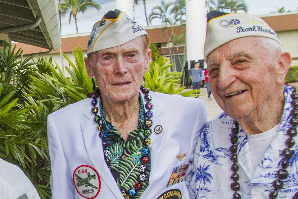 FILE - Pearl Harbor survivors Jack Holder, left, and Ed Stone pose for photos during a meet and greet with visitors at the Pearl Harbor Visitor Center, Dec. 5, 2016, in Honolulu. Holder, who went on become a decorated World War II flyer, has died in Arizona on Friday, Feb. 24, 2023. He was 101. (Dennis Oda/Honolulu Star-Advertiser via AP, FIle)