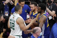 Boston Celtics forward Grant Williams (12) congratulates Golden State Warriors guard Stephen Curry (30) and forward Andrew Wiggins (22) after the Warriors defeated the Celtics in Game 6 of basketball's NBA Finals, Thursday, June 16, 2022, in Boston. (AP Photo/Michael Dwyer)