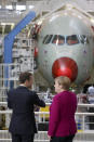 French President Emmanuel Macron and German Chancellor Angela Merkel visit the assembly line of the Airbus A350 in Toulouse, southwestern France, Wednesday, Oct.16, 2019. French President Emmanuel Macron and German Chancellor Angela Merkel are meeting in southern France, one day before a key EU summit that may approve a divorce deal with Britain. (AP Photo/Frederic Scheiber, Pool)