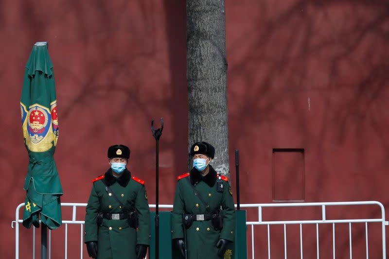 Paramilitary police officers stand guard at Tiananmen Square near the venue of the upcoming National People's Congress (NPC) in Beijing