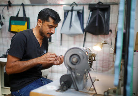 Migrant Abid Ali from Pakistan works as tailor and designer at the non-profit organization Mimycri, which recycles parts of a discarded dinghies into bags, in Berlin, Germany, July 23, 2018. REUTERS/Hannibal Hanschke