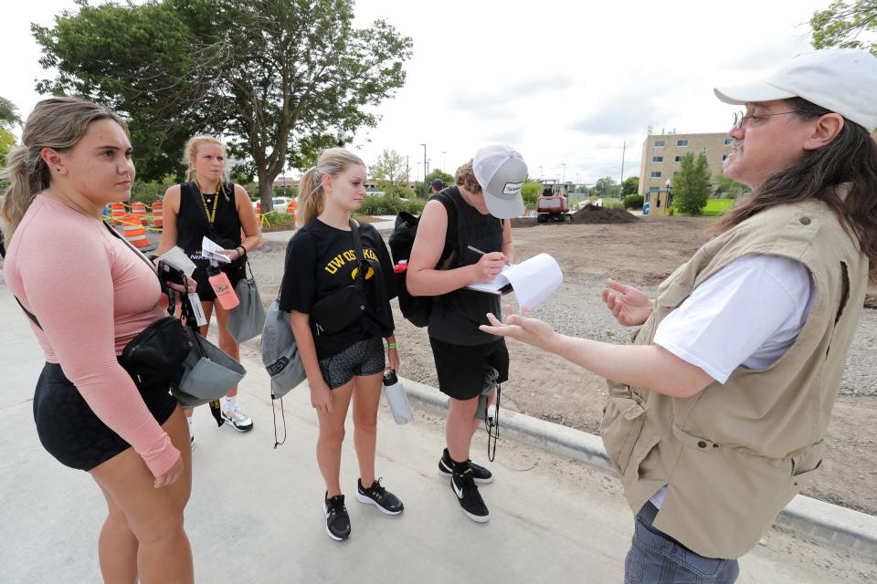 Third shift custodian Bob Knudsen, right, talks with students as they sign a petition against a potential plan to outsource custodial and janitorial jobs from the university on Tuesday, Sept. 6, 2022. David Siemers, a local chapter president for the American Federation of Teachers union said between multiple petitions, over 1,300 people signed against outsourcing the jobs.